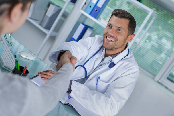 doctor shaking hands with patient in the office - Photo, image