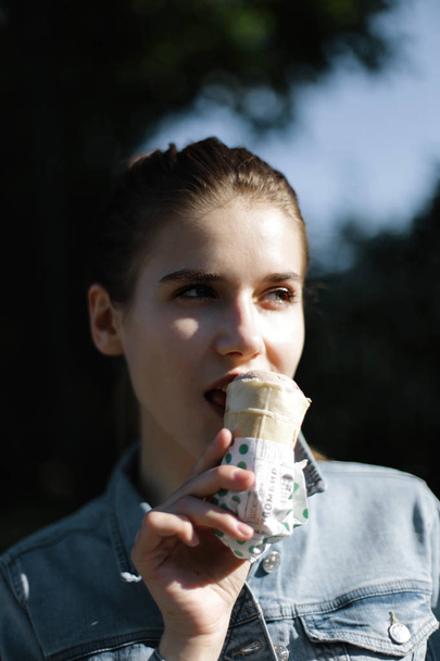 Girl eats chocolate ice cream in a waffle cup - Fotoğraf, Görsel