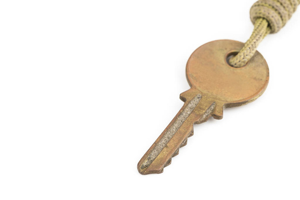 Stary klucz mosiądz z brelokiem na białym tle  - Zdjęcie, obraz