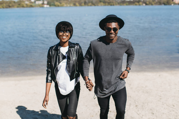 ビーチの上を歩いてアフリカのカップル - 写真・画像