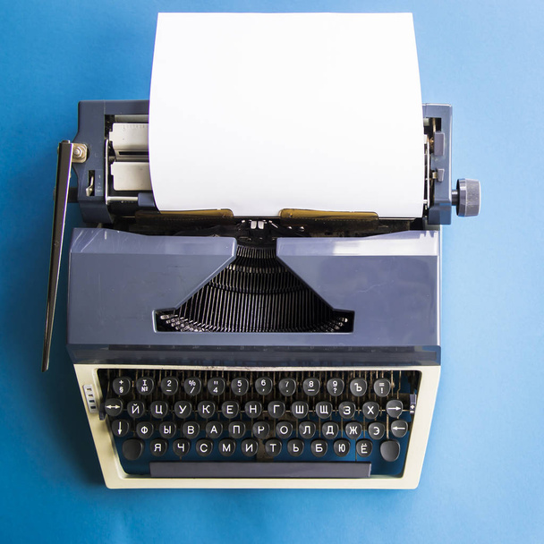 Schrijfmachine naast een strooien hoed en een kopje koffie - Foto, afbeelding