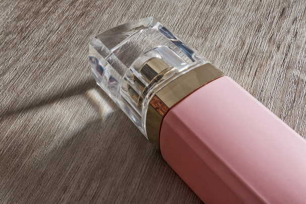 Perfume femenino, rosa aislado sobre fondo de madera
 - Foto, Imagen