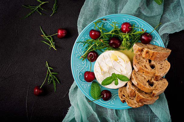 Baked Camembert cheese on blue plate - Photo, Image