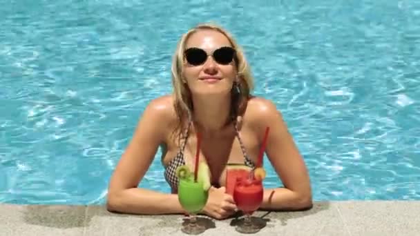 Krásná žena s koktejlem v bazénu. Dívka v plavkách, průzračné, ovocný koktejl. - Záběry, video