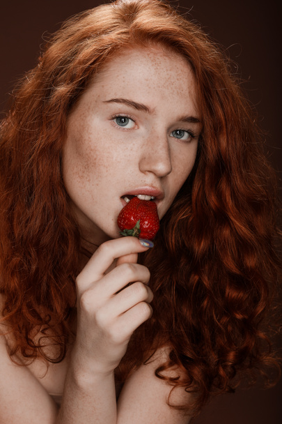 赤毛の女性はイチゴを食べる - 写真・画像