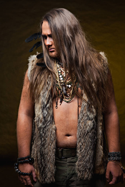  barbarian with decorations of beads and feathers - Foto, Imagen