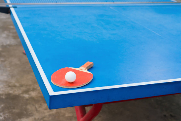 pingpong ρακέτα και μπάλα σε ένα μπλε pingpong τραπέζι - Φωτογραφία, εικόνα
