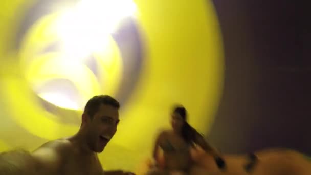 Friends having fun and sliding down in a colorful water slide - Video, Çekim
