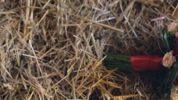 Ślubny bukiet róż, leżącego na słomie - Materiał filmowy, wideo