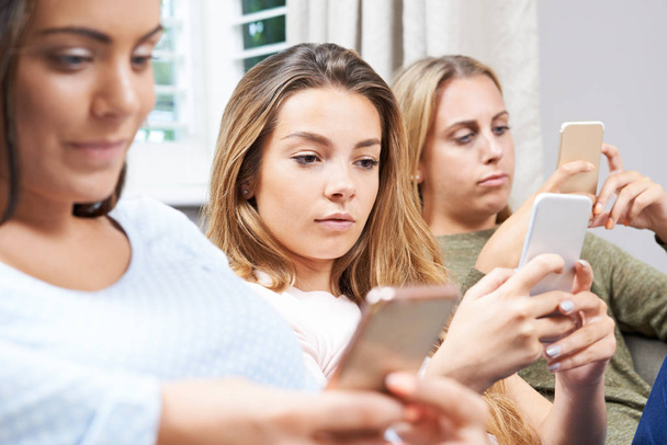 Group Of Teenage Girls Using Mobile Phones At Home - Valokuva, kuva