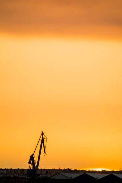 Пейзаж кранов в гавани на закате с облаками
 - Фото, изображение