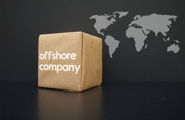 Offshore-yhtiöt ympäri maailmaa. Laatikkoon on kirjoitettu offshore-yritys. Taustalla maailmankartta
. - Valokuva, kuva