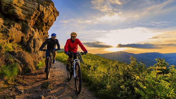 Górskie Kolarstwo kobiet i mężczyzna jazda na rowerach w sunset mountain - Zdjęcie, obraz