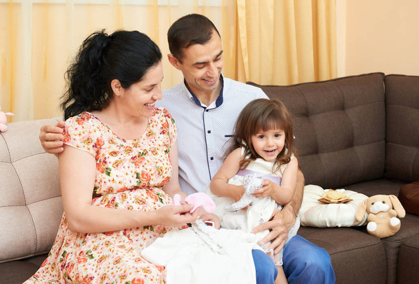 happy family with children indoor portrait, pregnant woman and man, beautiful people portrait sit on sofa - Foto, Imagen