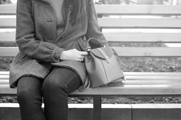 Woman sitting on bench with bag - Fotografie, Obrázek