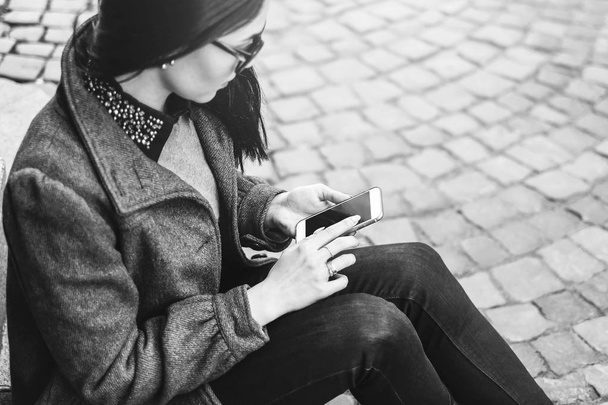 girl sitting on street with cellphone - Фото, изображение