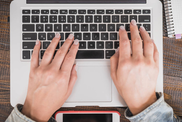 Praca Pani biznesowych. Kobiece rąk do pracy na nowoczesny laptop. Na drewnianym stole. Ramka pozioma - Zdjęcie, obraz