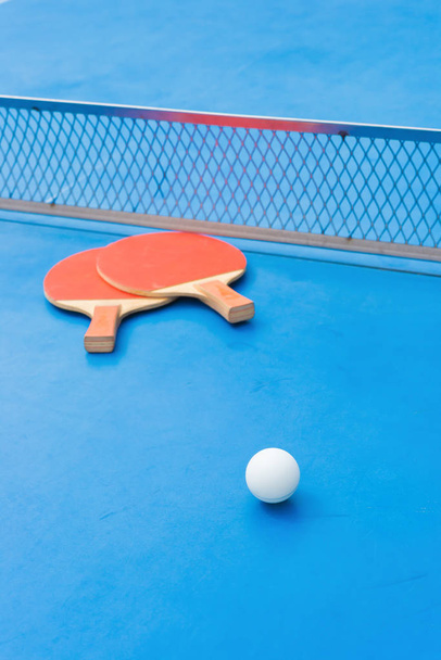 ピンポン ラケットとボールと青いピンポン テーブルでネット - 写真・画像