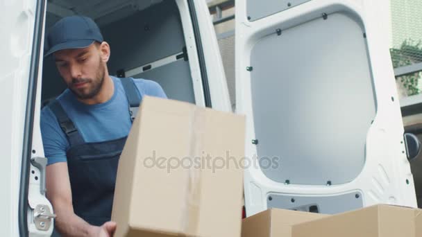 Strong Concentrated Delivery Man Loads his Cargo Van with Cardboard Boxes. - Filmati, video