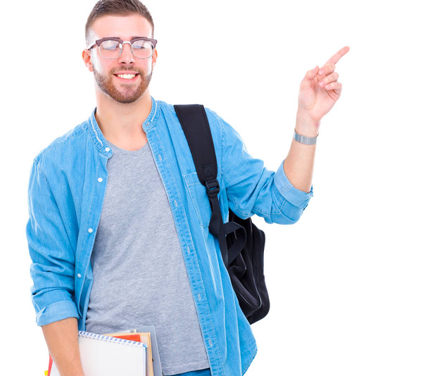 A male student with a school bag holding books and pointing isolated on white background - Foto, Imagem