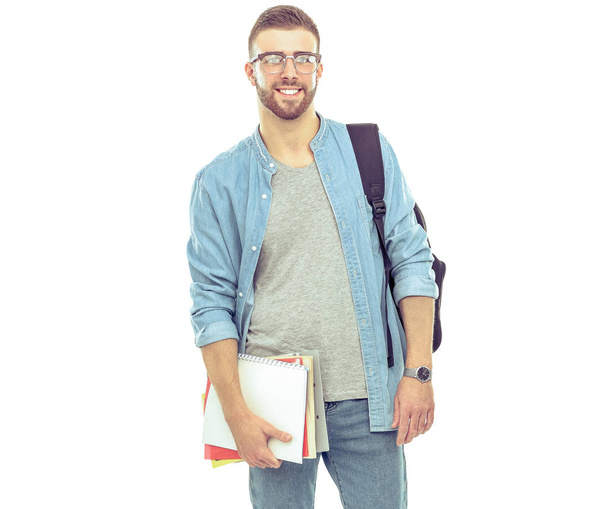 A male student with a school bag holding books isolated on white background - 写真・画像