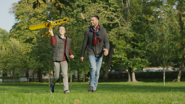 Father and Son are Running in with Model Airplane in the Park.  - Záběry, video
