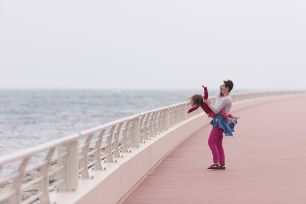 mother and cute little girl on the promenade by the sea - Foto, Bild