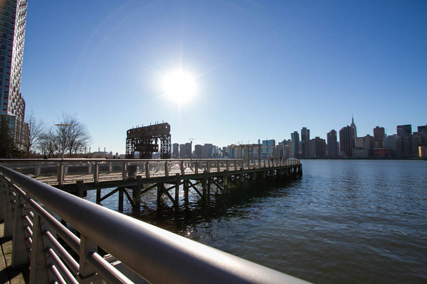 iconic gantries of Gantry State Park and fence of pier opposite city with blue sky, New York - Photo, Image
