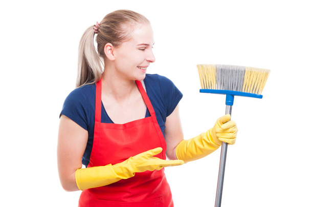 Pretty female cleaner showing her broom - Photo, Image