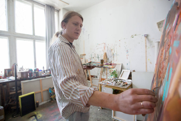Творчий чоловічий художник малює картини олійними фарбами
 - Фото, зображення