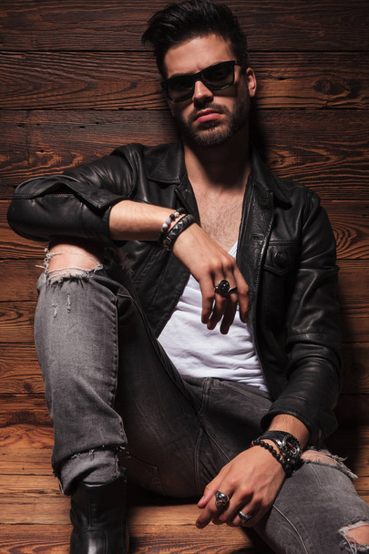 dramatic fashion man in leather jacket and sunglasses  sitting  - Foto, afbeelding