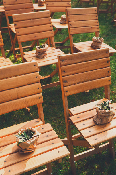 De ceremonie van het huwelijk, lege houten guest stoelen - Foto, afbeelding