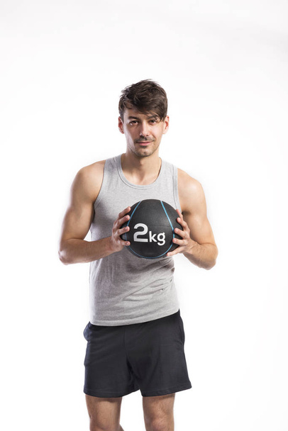 Handsome fitness man holding medicine ball, studio shot. - Foto, imagen