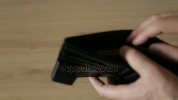 Un hombre saca billetes de un bolso de cuero
 - Metraje, vídeo