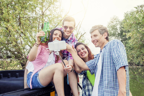 Gelukkig groep jonge vrienden roosteren met bier - Foto, afbeelding