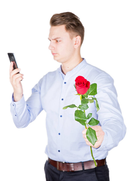 Handsome guy holding a red rose - Fotó, kép