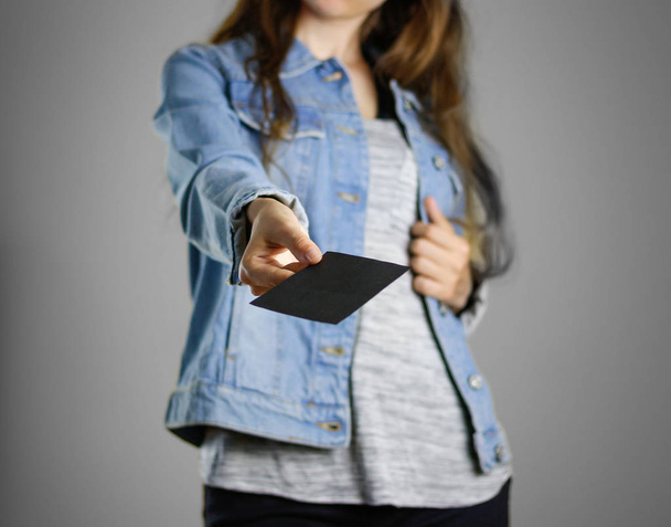 Dívka v modré džínové košili drží bílé prázdný kus  - Fotografie, Obrázek
