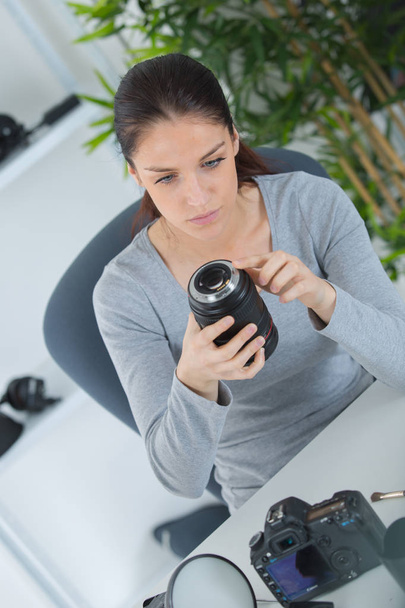 woman photographer fixing her dslr camera - Foto, afbeelding