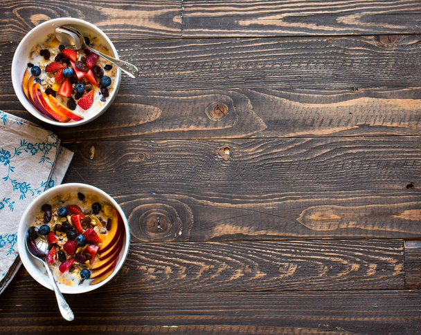 Healthy breakfast with milk,muesli and fruit, on a wooden backgr - Photo, image