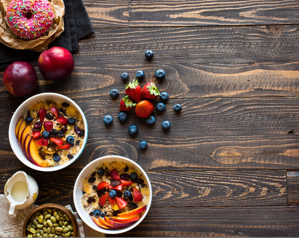 Healthy breakfast with milk,muesli and fruit, on a wooden backgr - Photo, image