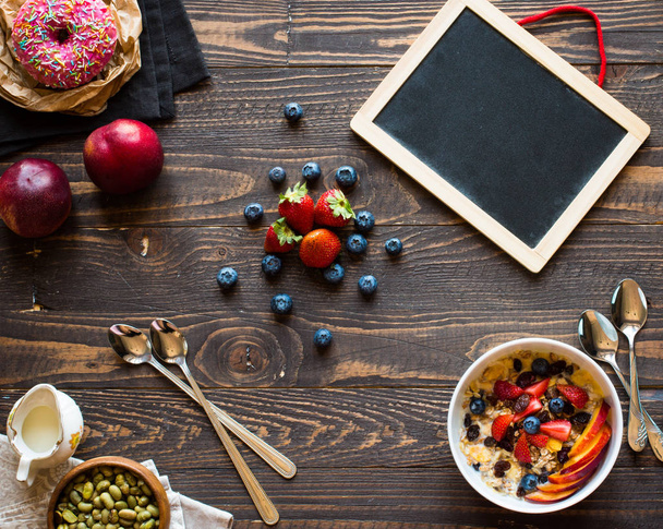 Desayuno saludable con leche, muesli y fruta, en un fondo de madera
 - Foto, Imagen