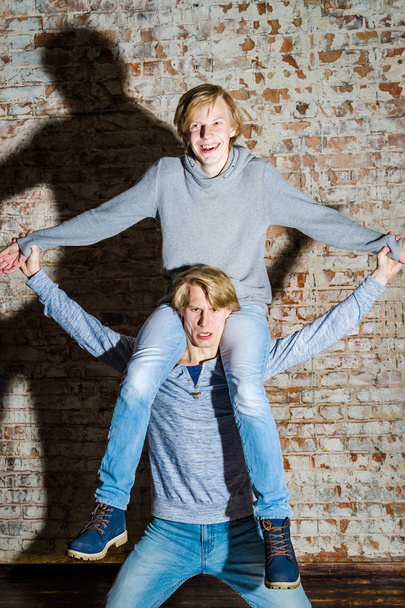 Two brothers posing in studio, teenage casual style - Fotoğraf, Görsel
