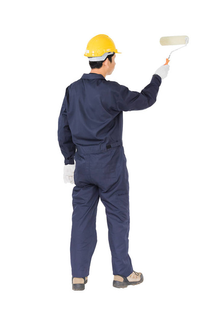 Работник в униформе с помощью краски ролика рисует невидимые f
 - Фото, изображение