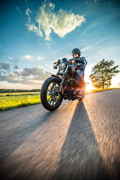 Man riding sportster motorcycle during sunset. - Zdjęcie, obraz