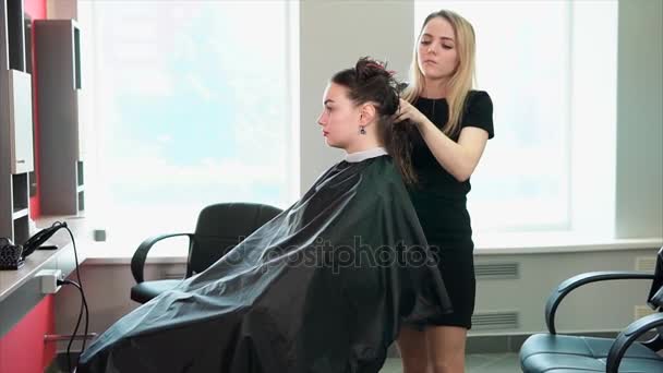 Fryzjerka uwiera mokre włosy aby wysuszyć w salonie piękności - Materiał filmowy, wideo