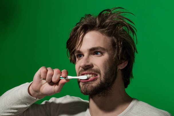 handsome young man brushing his teeth - 写真・画像
