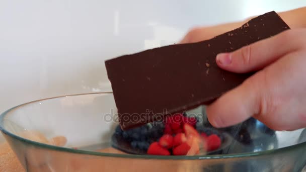 Μια γυναίκα σχάρες μια μπάρα σοκολάτας με έναν αποφλοιωτή πατάτας  - Πλάνα, βίντεο