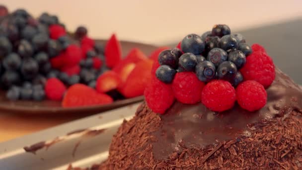 Een chocolate cake met frambozen en bosbessen bovenop - Video
