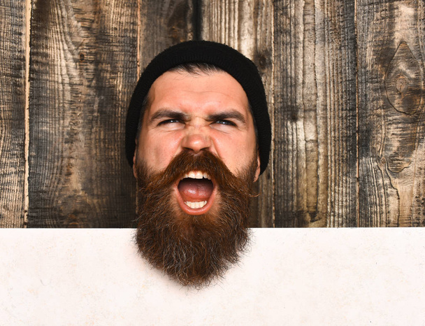 Bearded brutal caucasian hipster with white paper sheet - Фото, зображення