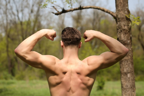 Biceps and back muscles of strong man with stylish haircut - Fotó, kép